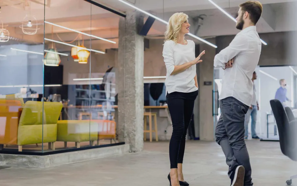 Two colleagues talking in a modern open-plan office